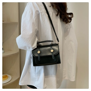 Classic black flap square bag with double strap buckles and a gold circular lock detail