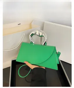 Vue détaillée du sac à main vert néon avec poignée en métal argenté style liquide