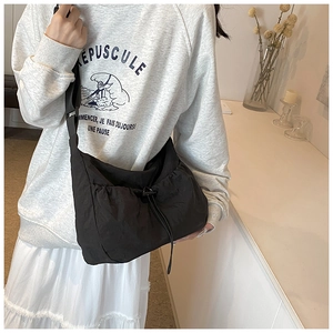Lightweight black nylon crossbody tote bag with drawstring closure and adjustable strap