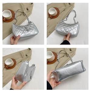 Detail view of silver baguette bag featuring quilted pattern and star buckle decoration