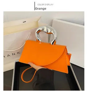 Détail du sac à main trapèze orange avec poignée en métal argenté élégante