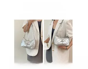 Silver quilted underarm bag with star charms shown in hand-carry and shoulder styles