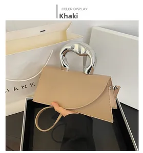 Détail du sac à main trapèze kaki avec sa poignée métallique argentée asymétrique