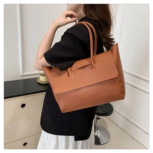 Brown leather tote bag detail showing the large capacity and stylish flap structure