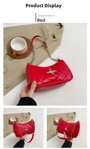 Detail of red quilted leather underarm bag with silver star ornament and chain strap