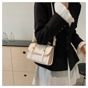 British style cream white square bag styled with a black blazer and pleated skirt