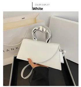 Gros plan du sac à main trapèze blanc avec poignée métallique ronde et bandoulière
