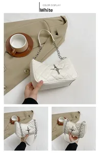 Close-up of white quilted PU leather underarm bag with metal star and chain strap