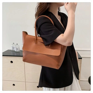 Detail of a large brown tote bag with long shoulder straps for versatile carrying options
