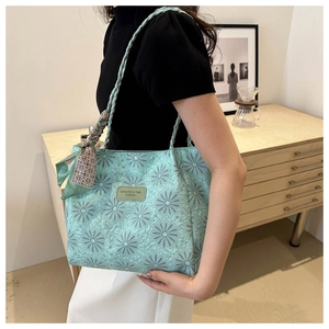 Detail of mint green tote bag featuring 3D daisy texture and decorative silk scarf