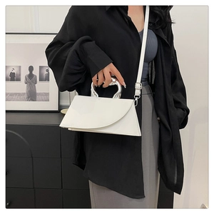 Détail du sac à main blanc géométrique avec poignée en métal argenté et bandoulière fine