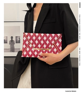 Detail of red and white plaid envelope clutch bag with premium gold metal trim