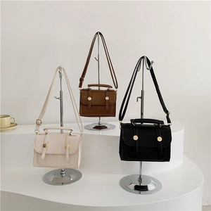 Minimalist square leather handbags in white, brown, and black with gold metal buckles