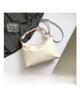 Detail of minimalist cream tote bag with contrast shoulder strap and fashion lettering