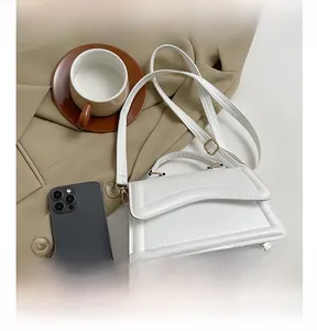 Détails du sac à main en cuir blanc avec texture ondulée et finitions métalliques dorées