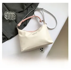 Detail of off-white faux leather shoulder bag with pink handle and mobile phone for size comparison