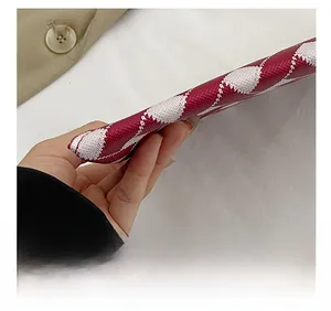 Macro view of red and white knit envelope bag showing precision stitching and fabric texture