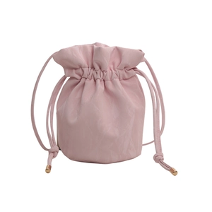 Pink drawstring bucket bag with pleated texture and golden metal tips on white background