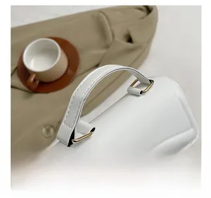 Détails de la poignée en cuir blanc avec finitions métalliques dorées élégantes
