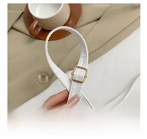 Détail de la bandoulière réglable en cuir blanc avec boucle dorée carrée pour sacs à main