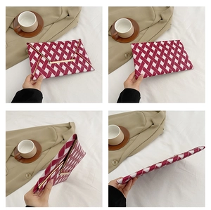 Detail of red and white woven geometric pattern envelope clutch with metal trim