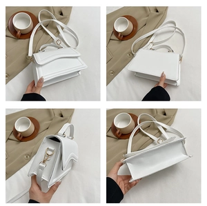 Détails d'un sac carré blanc avec rabat ondulé et accessoires en métal doré chic