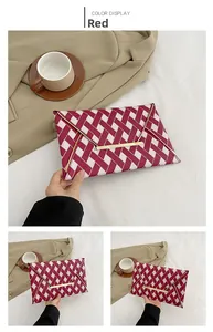 Detail view of red and white plaid fabric envelope clutch with gold metal trim