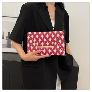 Detail of red and pink checkerboard clutch with elegant gold trim and metal bar closure