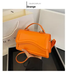Détail d'un sac carré élégant en cuir PU orange avec poignée et fermeture à rabat
