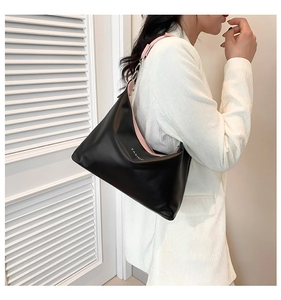 Detail of minimalist black hobo tote with pink interior and FASHION lettering text