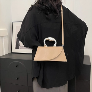 Sac bandoulière beige asymétrique chic avec poignée moderne en métal argenté