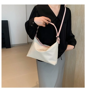 Detail of cream PU leather shoulder bag with FASHION lettering and pink strap