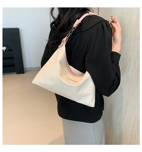 Detail of cream tote bag with pink strap and FASHION logo on waterproof fabric