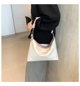 Hobo shoulder bag in beige and pink PU leather worn by a model in a minimalist setting