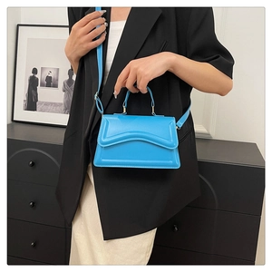 Sac à main bleu éclatant minimaliste avec motif ondulé présenté dans un cadre chic