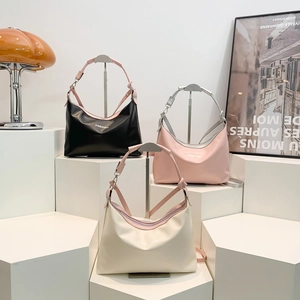 Three-color crescent leather tote bags in black, pink, and white on a modern studio display