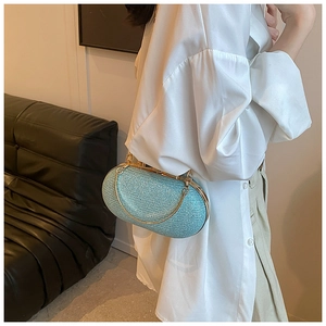 Close-up of sky blue evening clutch with shimmering sequins and gold chain strap