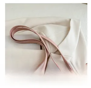 Close-up of pink tote bag showing silver metal rings and slender shoulder straps