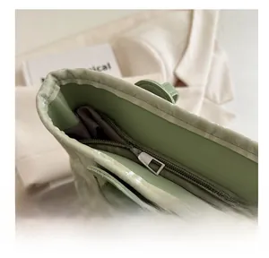 Detailed view of the smooth silver zipper and mint green faux leather of the tote bag