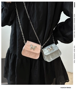 Detail of mini chain crossbody bags in pink and blue with silver butterfly accents