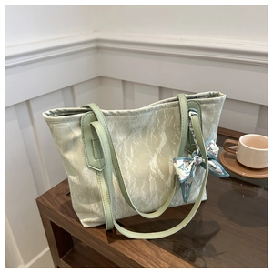 Detail of light green tote bag with natural pleated texture and fashion print silk scarf