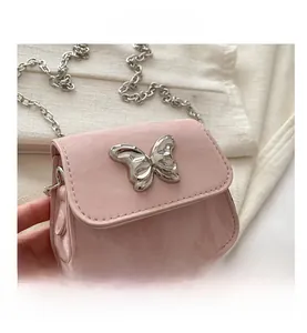 Close-up of pink mini chain bag featuring a silver butterfly buckle and embossed leather