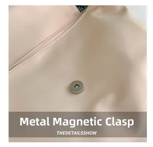 Detail of the silver magnetic snap closure on a light pink leather tote shoulder bag