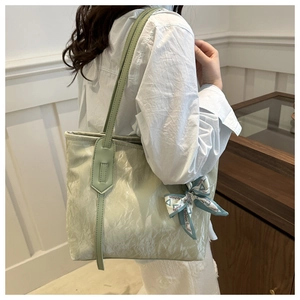 Detail of light green tote bag with crinkled texture and fashion print silk scarf accessory