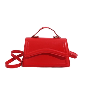 Sac à main rouge élégant avec rabat ondulé et détails dorés sur fond blanc