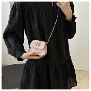 Pink mini crossbody bag with a silver butterfly buckle and delicate chain strap details