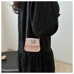Detail view of pink mini chain bag with silver butterfly buckle and marble texture