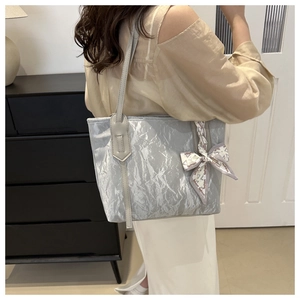 Detail der silbernen Falten-Tote-Bag mit modischer Schleife am Griff für den Alltag