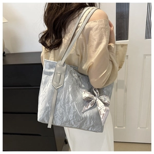 Dettaglio della borsa tote azzurra stropicciata con foulard decorativo su modella