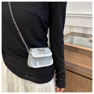 Dettaglio della mini borsa a tracolla marmorizzata con chiusura a farfalla lucida